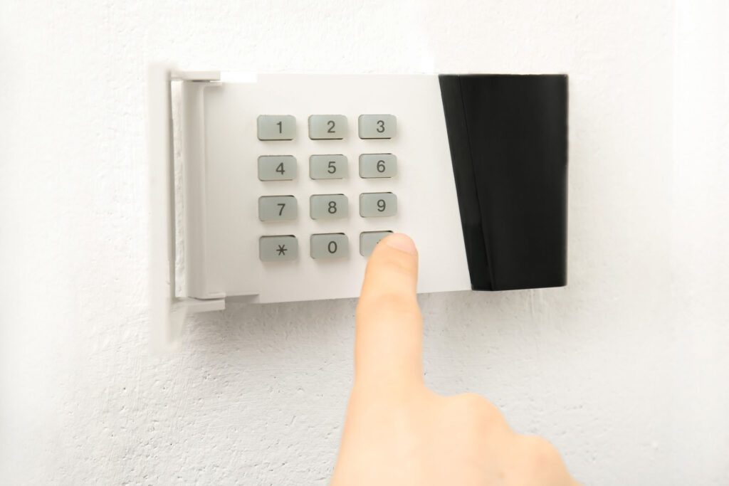 A person types in a code on a keypad to unlock a door.