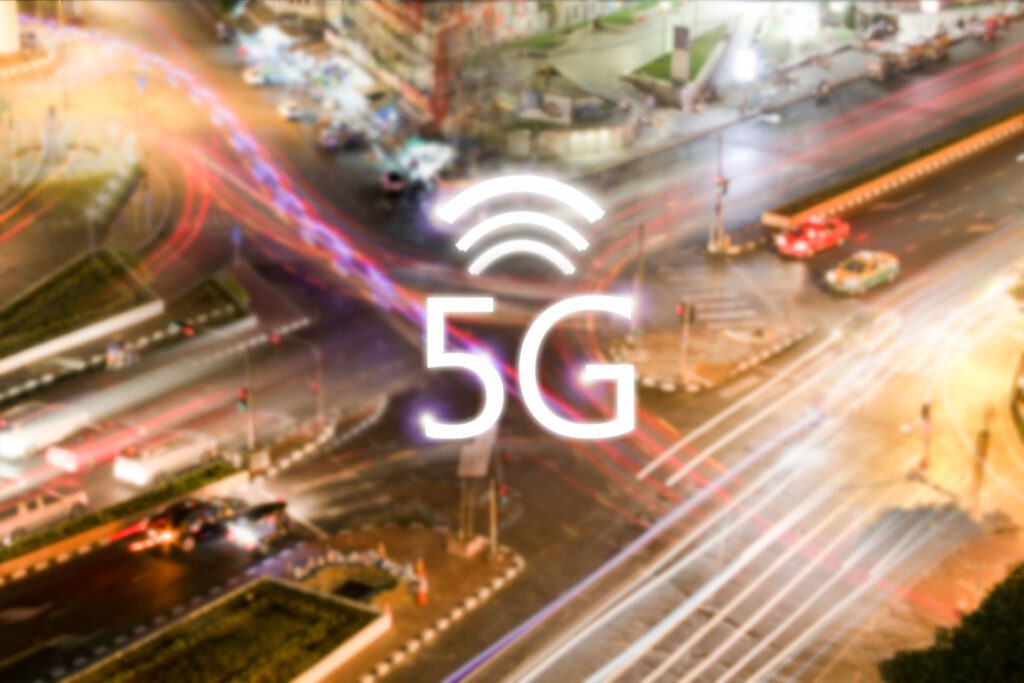 “5G” with a busy street and buildings in the background.