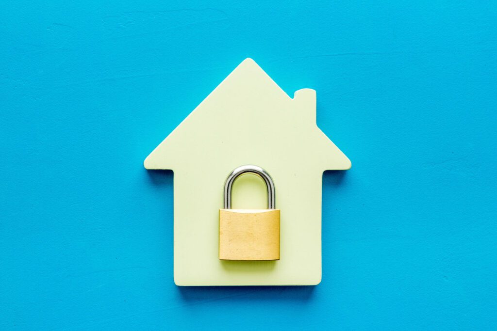 Wooden outline of a home with a lock in the center.