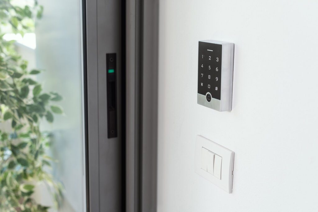 Keypad next to a sliding door and a light switch.