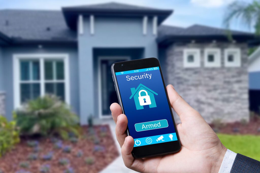 Man holding a cell phone with the words “security” and “armed” on the screen with a house in the background.