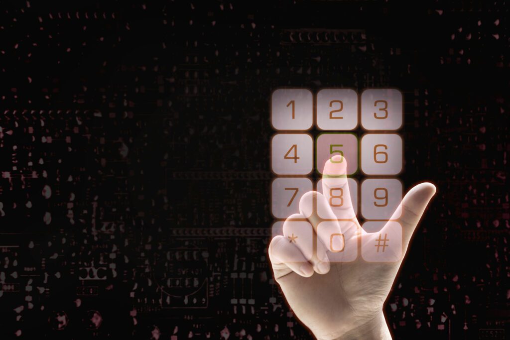 A person types in a security code on a digital keypad against a black background.