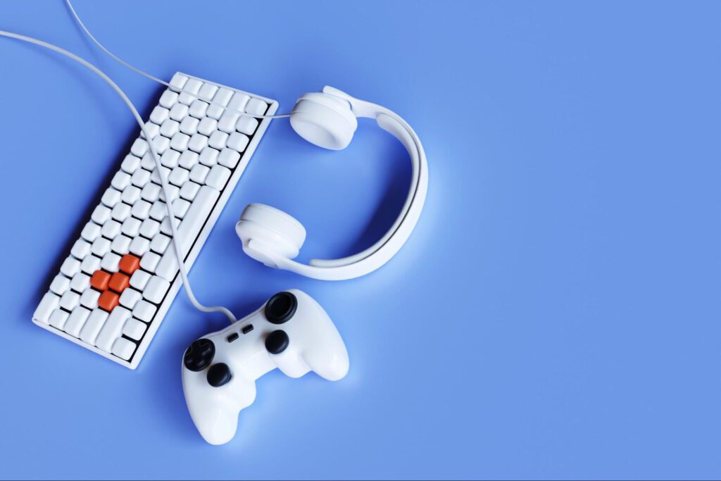 A keyboard, headphones, and a gaming controller sit on a light blue background.