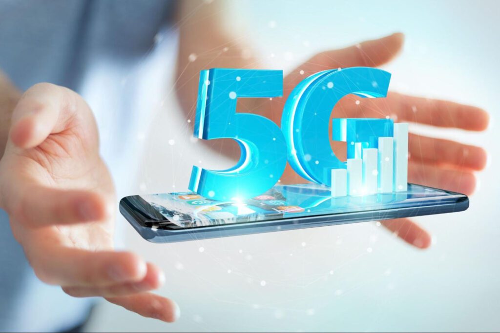 3D 5G coming up from a phone screen with a person with outstretched arms in the background.