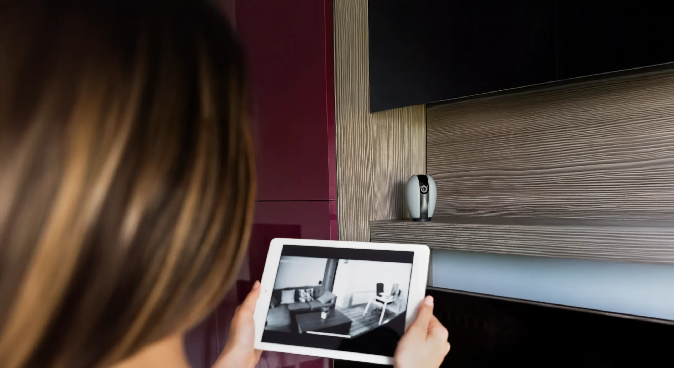 Woman viewing security footage on tablet.